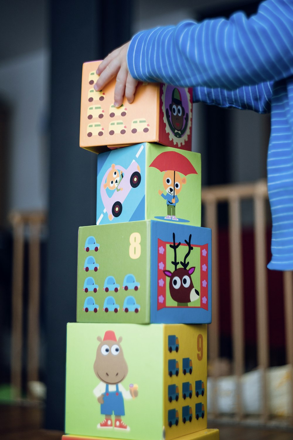 A child stacking colorful illustrated blocks