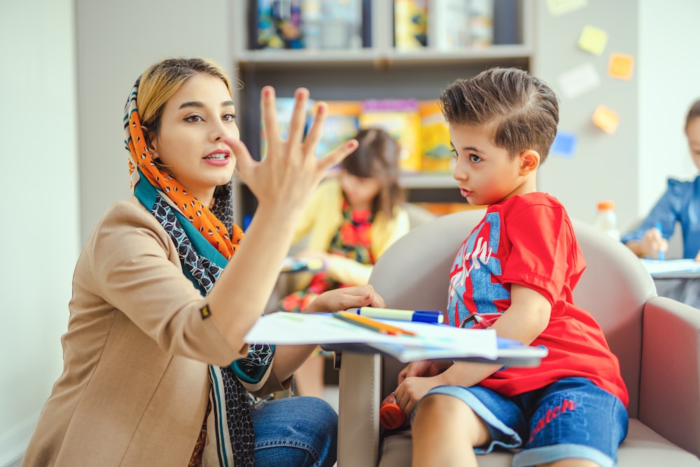 A teacher counting on her fingers with a young student